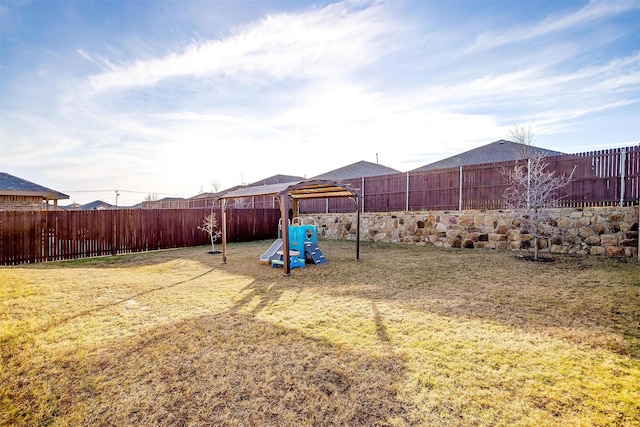 view of yard featuring a playground and a fenced backyard