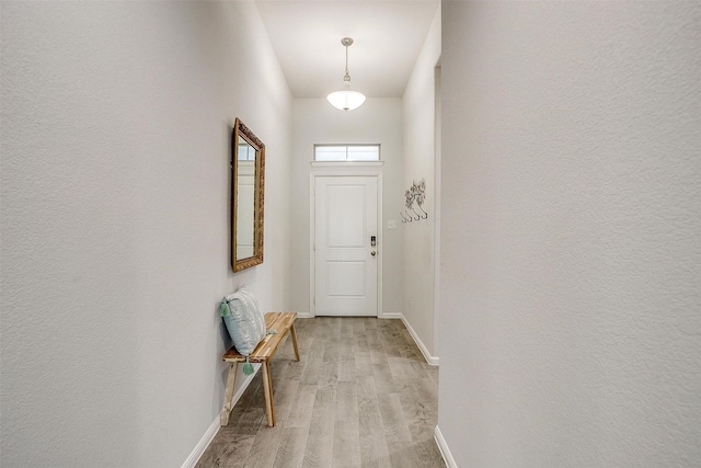 doorway to outside featuring light wood-type flooring and baseboards