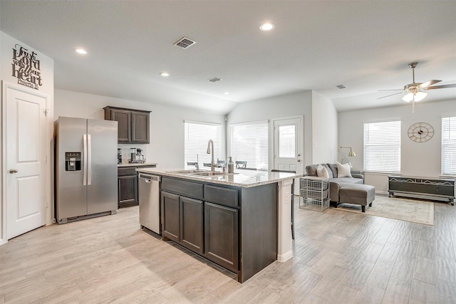 kitchen featuring dark brown cabinetry, visible vents, appliances with stainless steel finishes, a sink, and a wealth of natural light