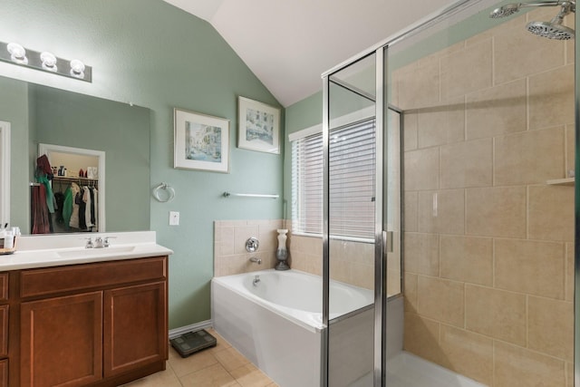 bathroom with tile patterned flooring, vanity, vaulted ceiling, a bath, and a stall shower