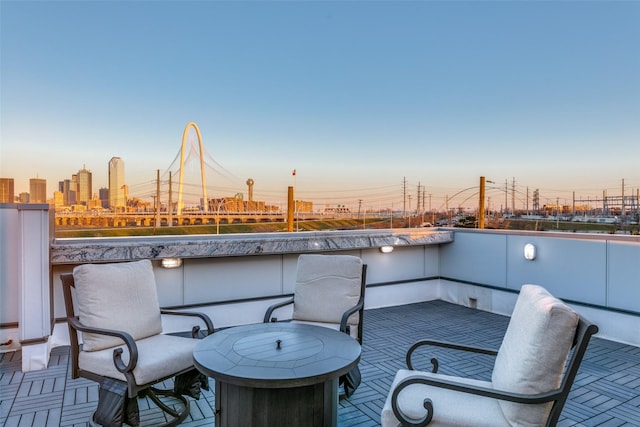 patio terrace at dusk featuring a city view and a balcony