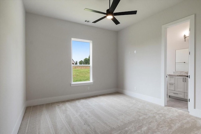 unfurnished bedroom with light colored carpet, connected bathroom, visible vents, and baseboards