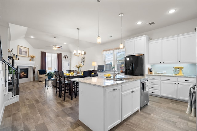 kitchen with a glass covered fireplace, a healthy amount of sunlight, freestanding refrigerator, and a sink