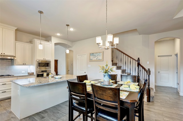 2101 Bishop Barrel Ln, Wylie, TX 75098 - dining space featuring arched walkways, recessed lighting, a chandelier, and light wood finished floors