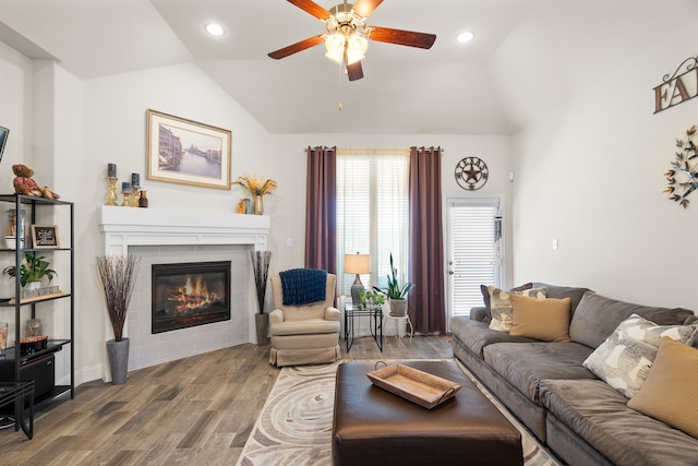 living room featuring a fireplace, vaulted ceiling, wood finished floors, and recessed lighting