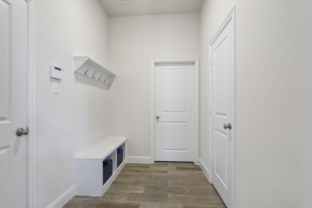 mudroom with dark wood-style floors and baseboards