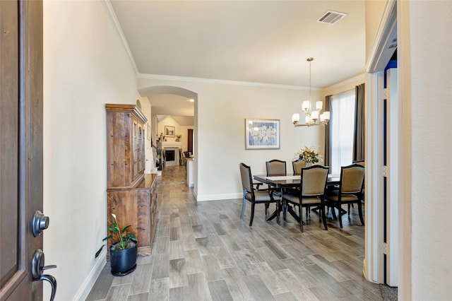 2101 Bishop Barrel Ln, Wylie, TX 75098 - dining area featuring arched walkways, baseboards, ornamental molding, and light wood-style flooring