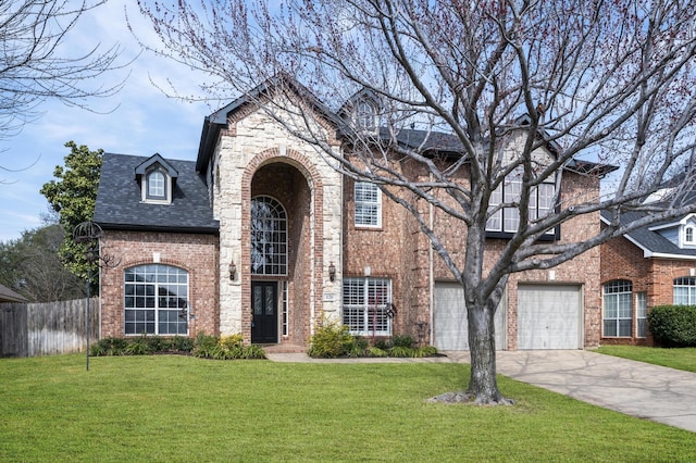 view of front of house with brick siding, concrete driveway, an attached garage, a front yard, and fence