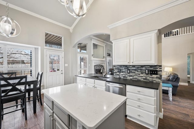 kitchen featuring tasteful backsplash, dishwasher, dark wood-style floors, crown molding, and a sink