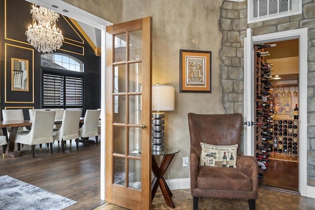 sitting room featuring french doors, a notable chandelier, visible vents, wood finished floors, and baseboards