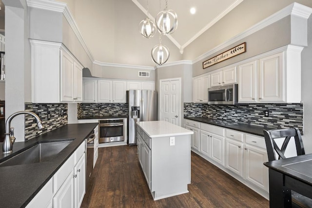 kitchen with visible vents, white cabinets, appliances with stainless steel finishes, crown molding, and a sink