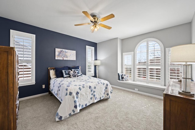 carpeted bedroom with a ceiling fan and baseboards