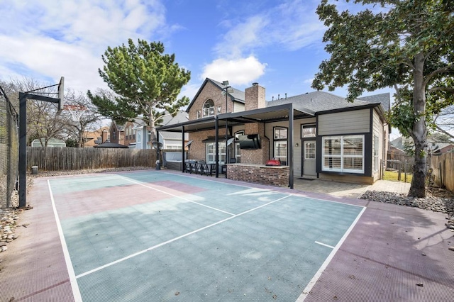 view of sport court featuring a fenced backyard and basketball court