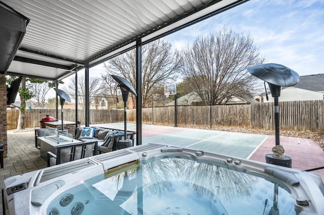 view of swimming pool with a patio area, a fenced backyard, and an outdoor hot tub