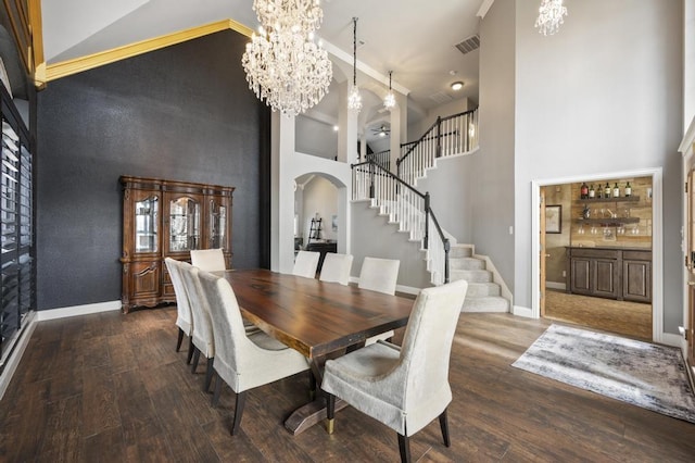 dining area with visible vents, a chandelier, arched walkways, and wood finished floors