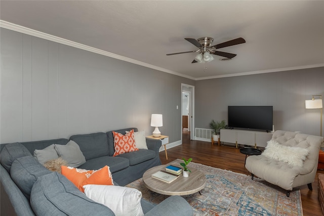 living room featuring ornamental molding, visible vents, ceiling fan, and wood finished floors