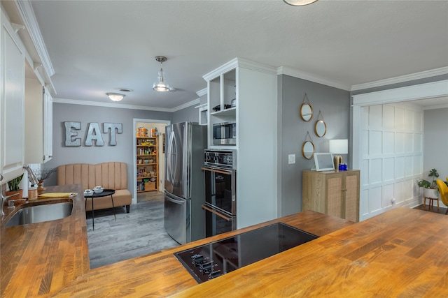 kitchen with crown molding, open shelves, a sink, wood counters, and black appliances