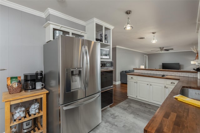 kitchen featuring butcher block counters, white cabinetry, light wood-type flooring, black appliances, and crown molding