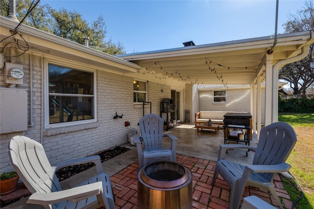 view of patio / terrace with an outdoor living space with a fire pit and area for grilling