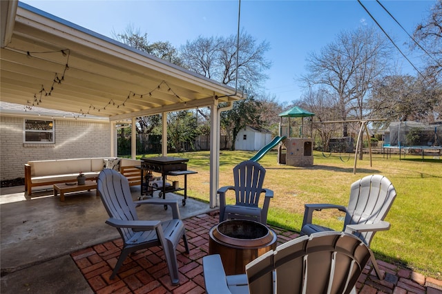 view of patio with an outdoor living space with a fire pit, a trampoline, a playground, and a fenced backyard