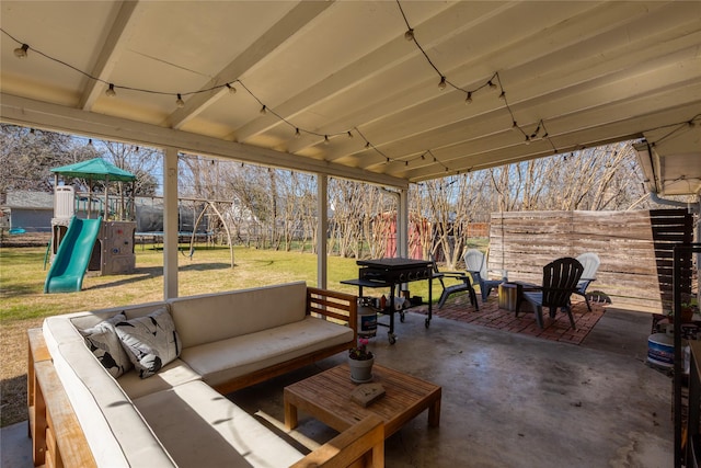 view of patio with a trampoline, fence, an outdoor hangout area, and a playground