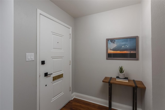 entryway featuring dark wood-type flooring and baseboards