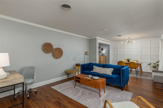 living area with baseboards, visible vents, wood finished floors, crown molding, and a chandelier