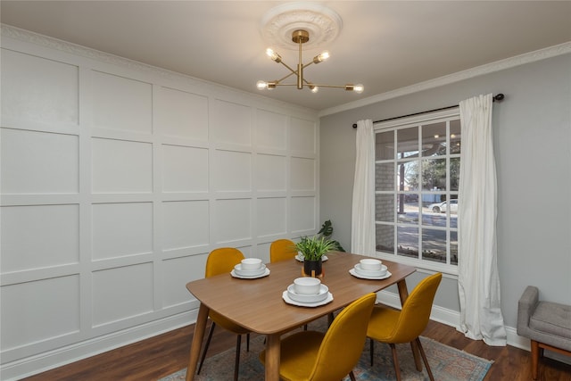 dining area featuring a chandelier, a decorative wall, baseboards, dark wood finished floors, and crown molding