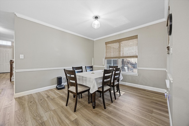 dining space with ornamental molding, wood finished floors, and baseboards