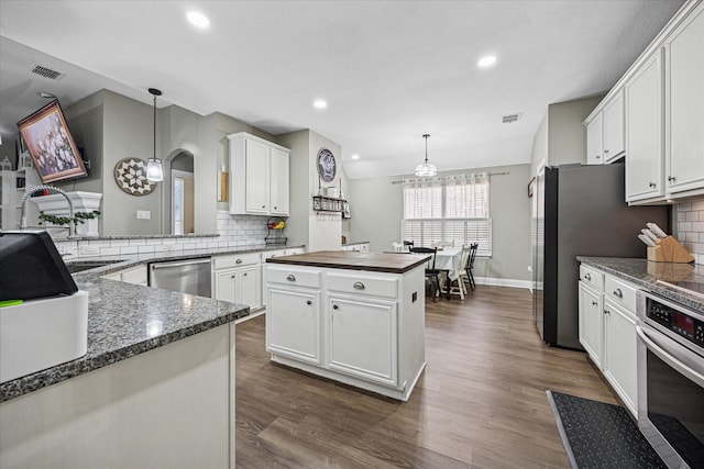 kitchen featuring white cabinets, visible vents, stainless steel appliances, and dark wood finished floors