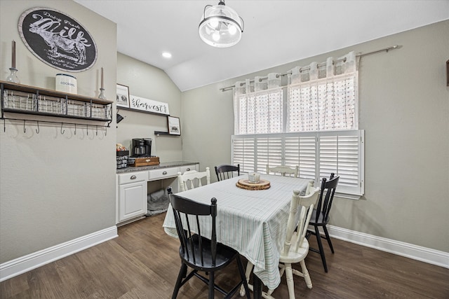 dining room featuring lofted ceiling, dark wood-style flooring, built in study area, and baseboards