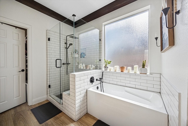 full bathroom featuring a bath, a shower stall, and wood finished floors