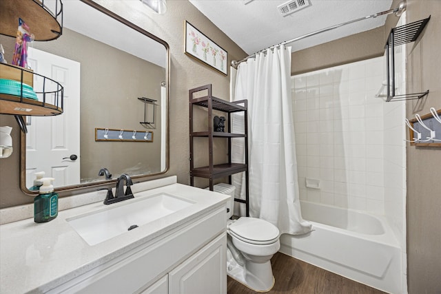 bathroom with shower / tub combo with curtain, visible vents, toilet, vanity, and wood finished floors