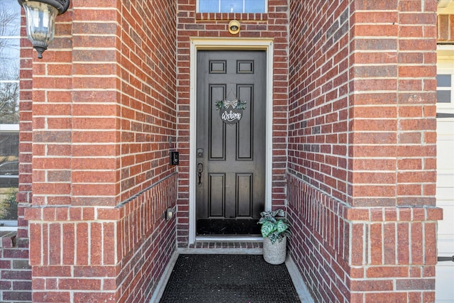 doorway to property featuring brick siding