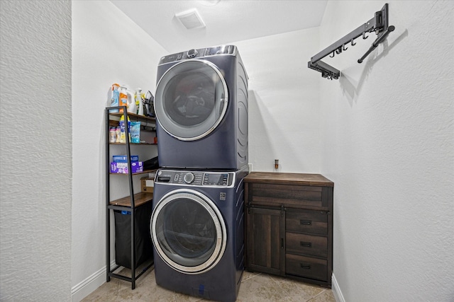 laundry room with laundry area, baseboards, and stacked washer / drying machine