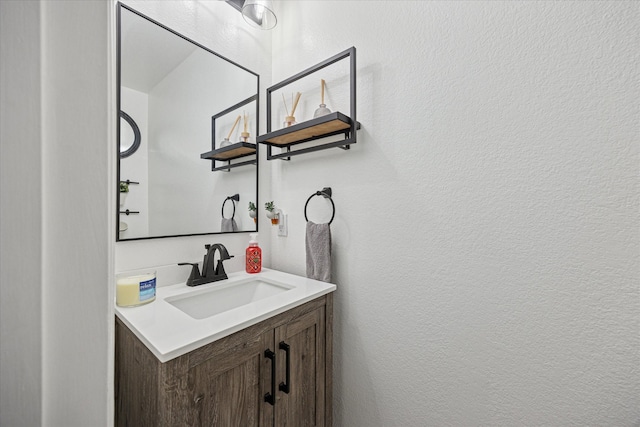 bathroom with a textured wall and vanity