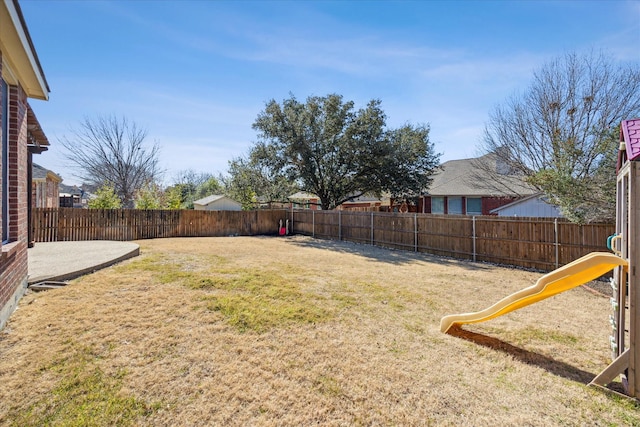 view of yard with a fenced backyard, a playground, and a patio