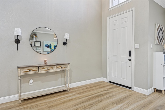 foyer featuring baseboards and wood finished floors