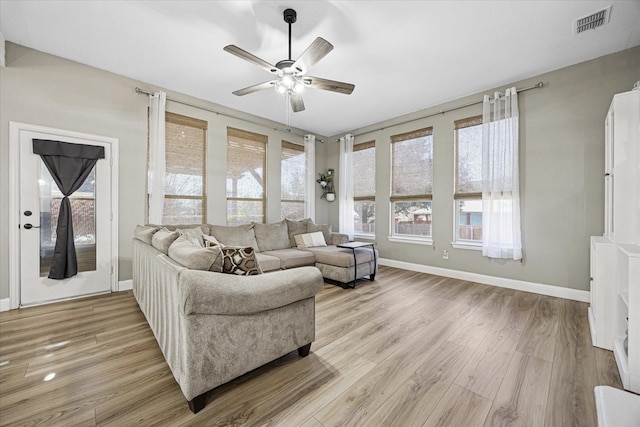 living area with light wood-type flooring, baseboards, visible vents, and a ceiling fan