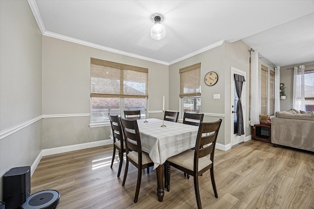 dining space with crown molding, light wood finished floors, and baseboards