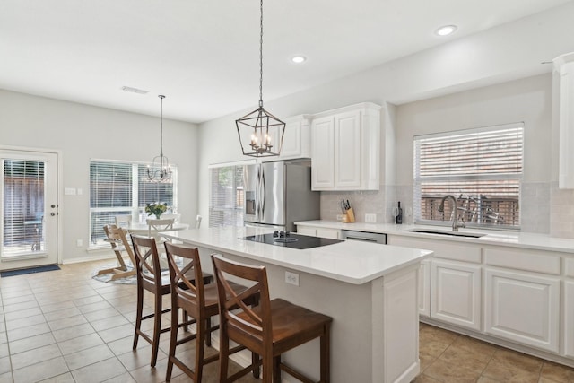 kitchen featuring light countertops, appliances with stainless steel finishes, a sink, and decorative backsplash