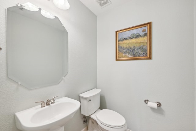 bathroom with visible vents, a sink, and toilet