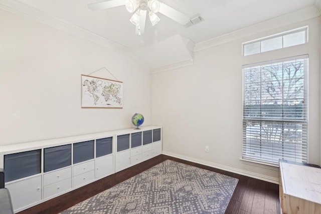 interior space featuring ceiling fan, dark wood-type flooring, visible vents, baseboards, and ornamental molding