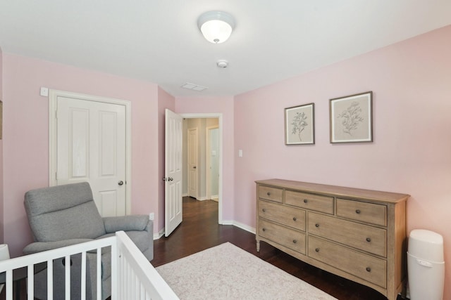 bedroom with dark wood finished floors and baseboards