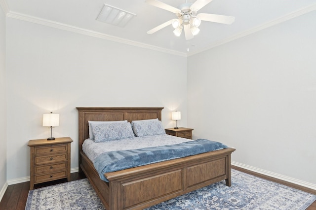 bedroom featuring visible vents, crown molding, baseboards, and wood finished floors