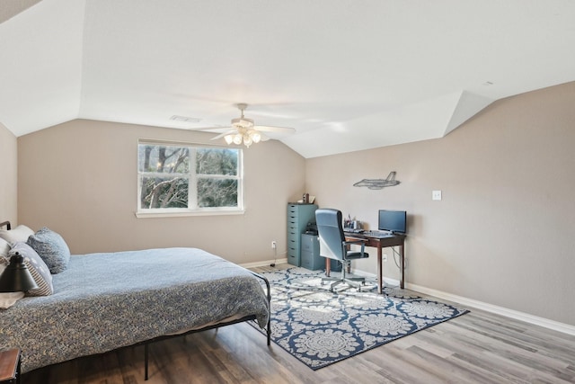 bedroom with visible vents, baseboards, a ceiling fan, lofted ceiling, and wood finished floors