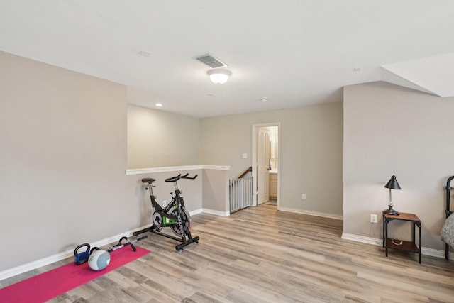 workout area with light wood-style floors, recessed lighting, visible vents, and baseboards