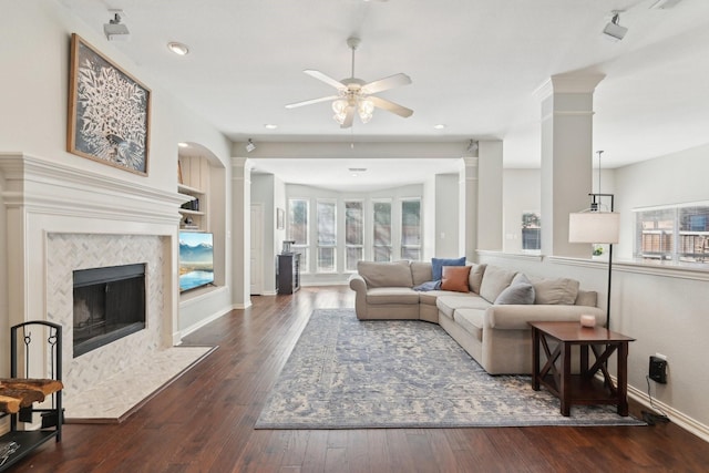 living room with hardwood / wood-style flooring, plenty of natural light, ornate columns, and a high end fireplace