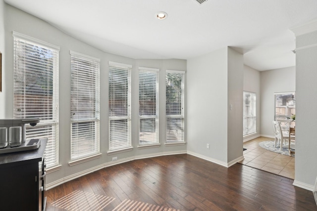 interior space featuring wood-type flooring and baseboards