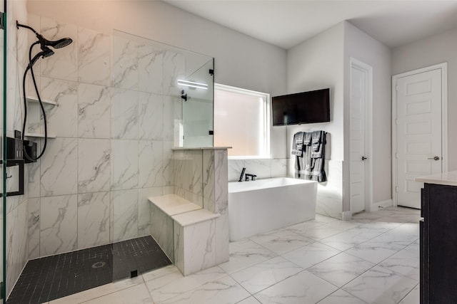 bathroom featuring marble finish floor, a walk in shower, and a freestanding bath